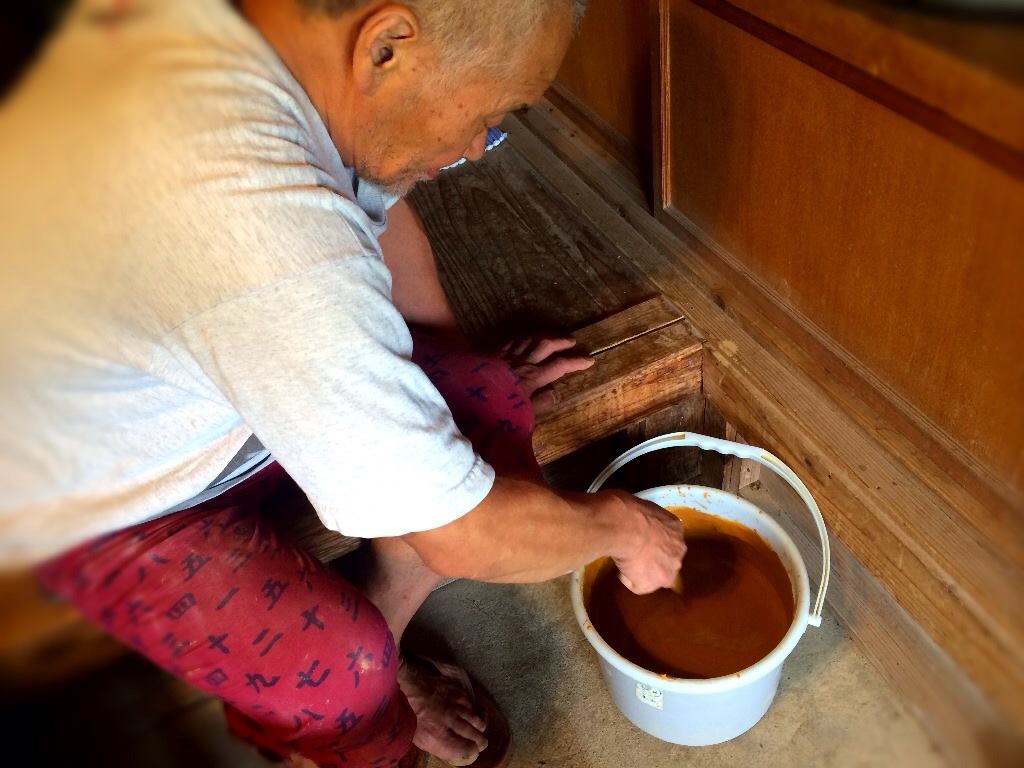 鉄分が多く含まれた成島土を水で溶かす水野先生